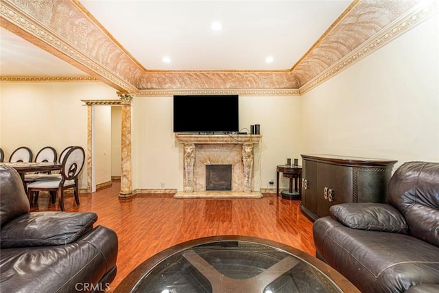 living room featuring hardwood / wood-style flooring, a premium fireplace, and crown molding