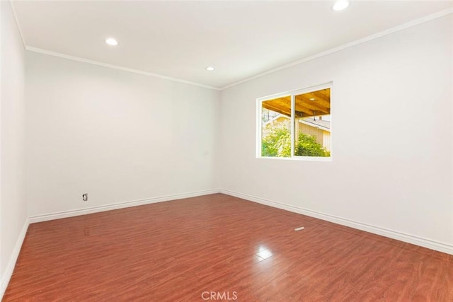 empty room with crown molding and hardwood / wood-style floors