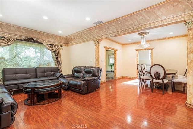 living room with decorative columns, ornamental molding, and hardwood / wood-style flooring