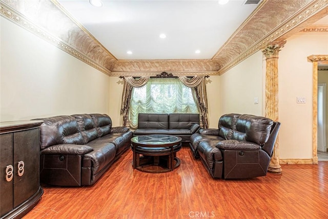 living room with wood-type flooring, ornamental molding, and decorative columns