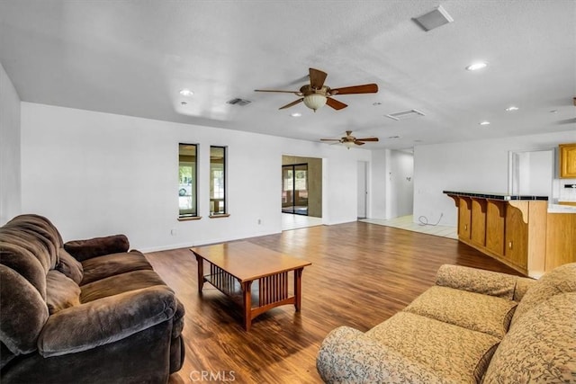 living room featuring hardwood / wood-style floors and ceiling fan