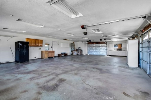 garage with black refrigerator and a garage door opener