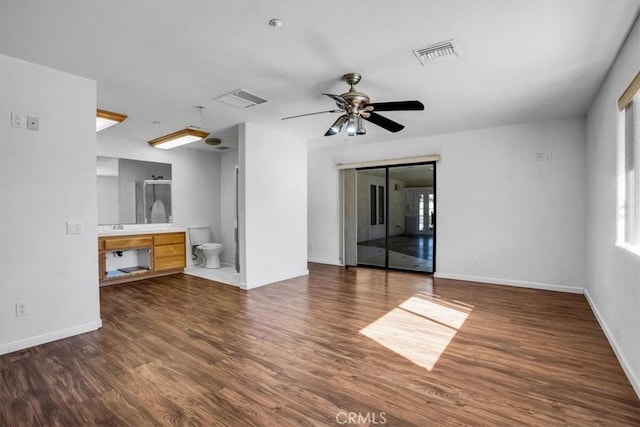 unfurnished living room with dark hardwood / wood-style flooring and ceiling fan