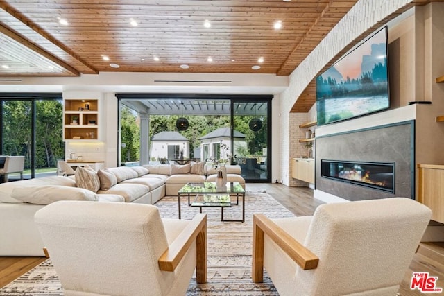 living room featuring built in features, light hardwood / wood-style flooring, and wooden ceiling