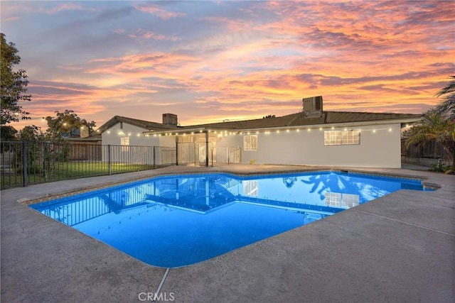 pool at dusk featuring a patio area