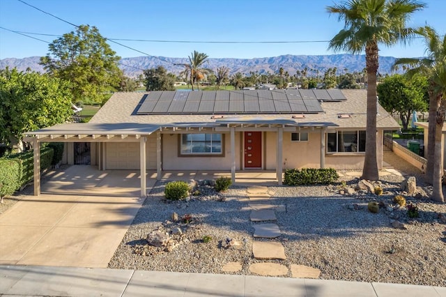 view of front of house featuring solar panels, a garage, and a mountain view