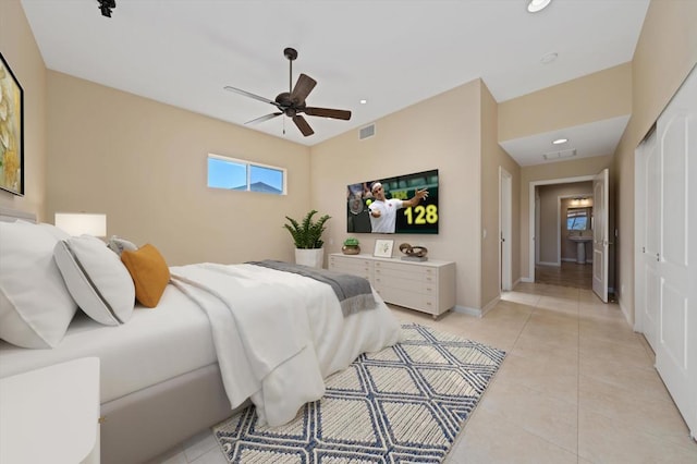 bedroom featuring light tile patterned floors, a closet, and ceiling fan