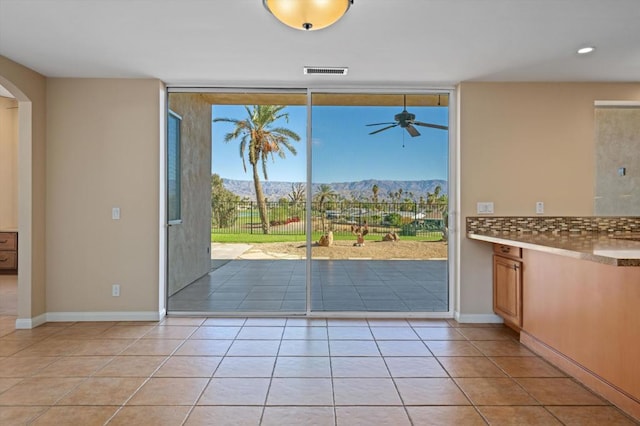 doorway to outside featuring a mountain view and light tile patterned floors