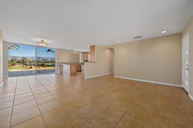 unfurnished living room with ceiling fan and light tile patterned floors