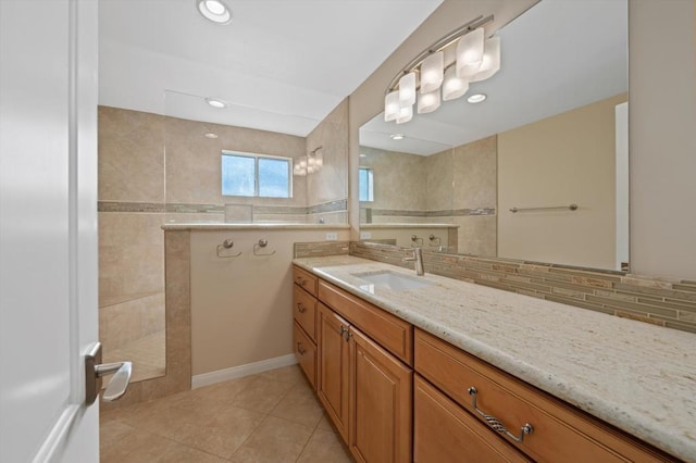 bathroom with tile patterned floors, decorative backsplash, vanity, and a tile shower