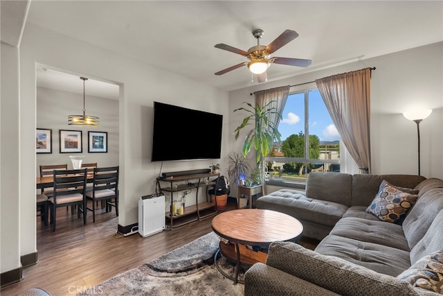 living room featuring ceiling fan and dark hardwood / wood-style floors