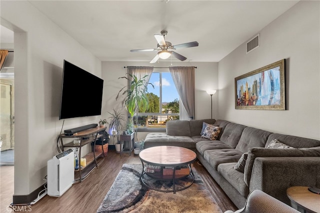 living room featuring ceiling fan and dark hardwood / wood-style floors