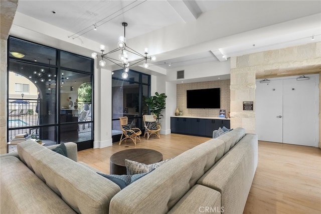 living room featuring hardwood / wood-style floors, beamed ceiling, and a notable chandelier