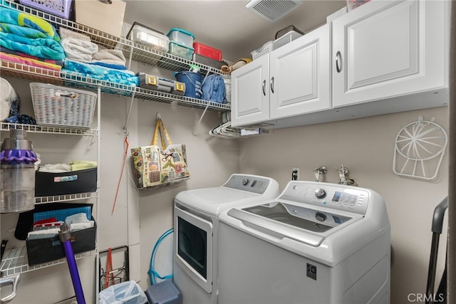 laundry area featuring cabinets and washer and clothes dryer