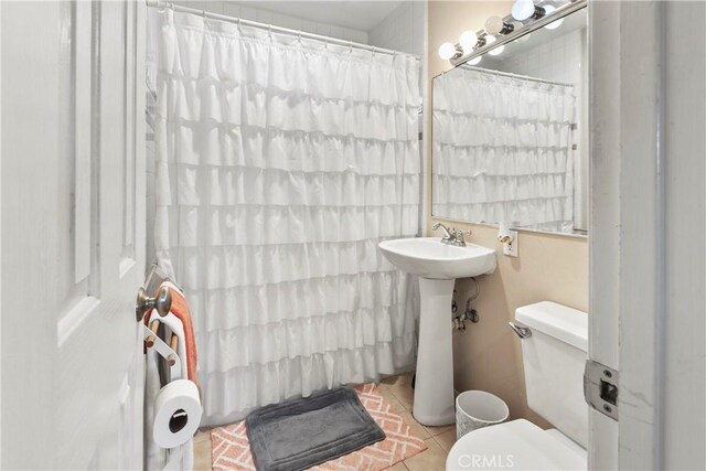 bathroom featuring a shower with curtain, tile patterned floors, and toilet