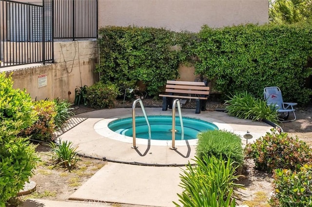 view of swimming pool featuring a hot tub