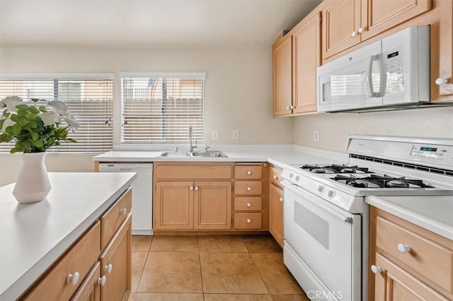 kitchen featuring white appliances, light brown cabinetry, sink, and light tile patterned floors