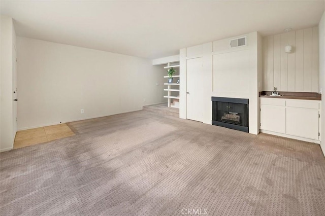 unfurnished living room featuring light carpet