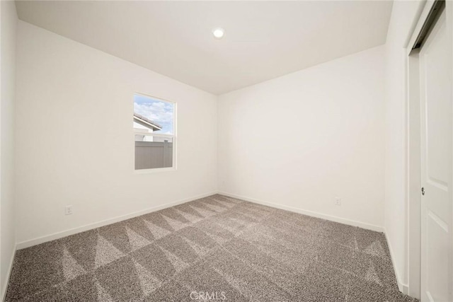 empty room featuring recessed lighting, carpet flooring, and baseboards