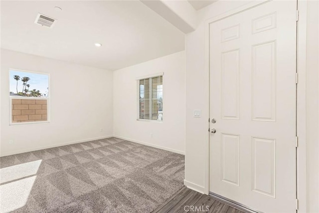 unfurnished room featuring carpet floors, visible vents, and baseboards