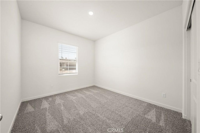 carpeted empty room featuring baseboards