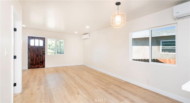 entryway with a wall unit AC, recessed lighting, baseboards, a wall mounted AC, and light wood-type flooring