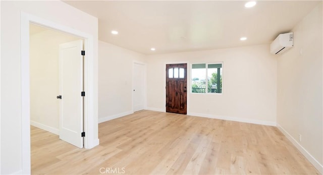 entryway with recessed lighting, a wall mounted air conditioner, and light wood finished floors