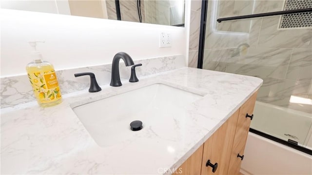 bathroom featuring a shower with door and vanity