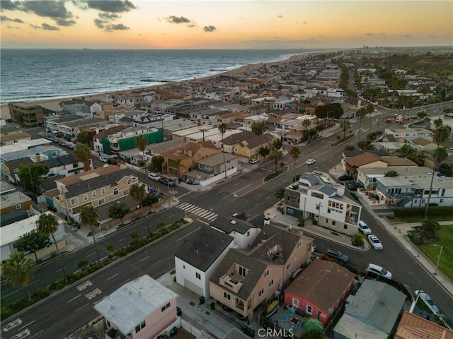 aerial view at dusk featuring a water view