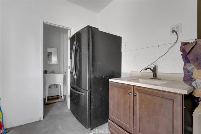 kitchen featuring black fridge with ice dispenser and sink