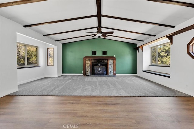 unfurnished living room with hardwood / wood-style flooring, ceiling fan, and vaulted ceiling with beams