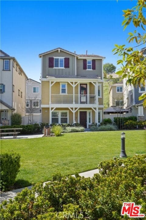 view of front facade with a balcony and a front yard