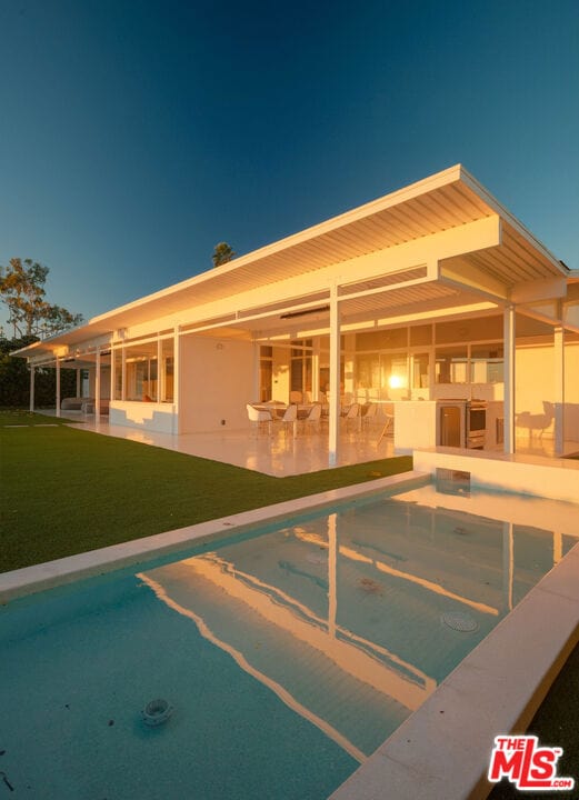 view of pool with a patio and a lawn