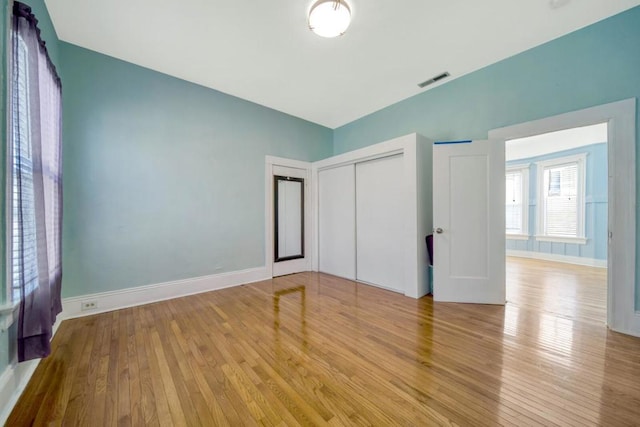 unfurnished bedroom featuring light hardwood / wood-style flooring and a closet