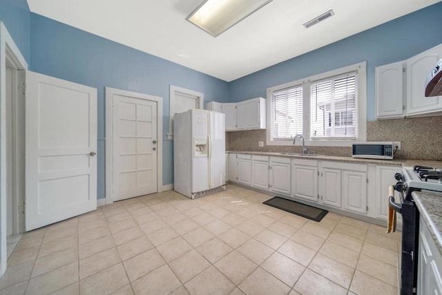 kitchen with white cabinets, white refrigerator with ice dispenser, and stove