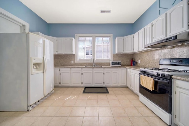 kitchen featuring white fridge with ice dispenser, white cabinets, sink, gas range, and light tile patterned floors