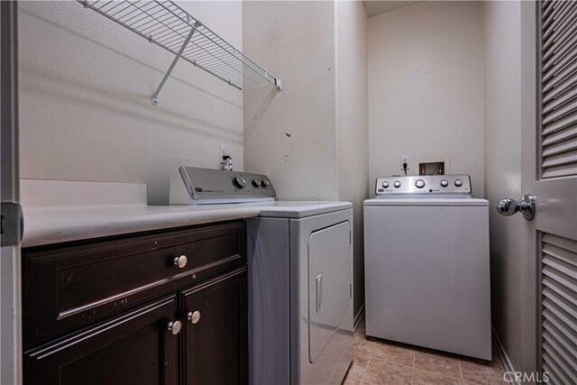 washroom with washing machine and clothes dryer and cabinets