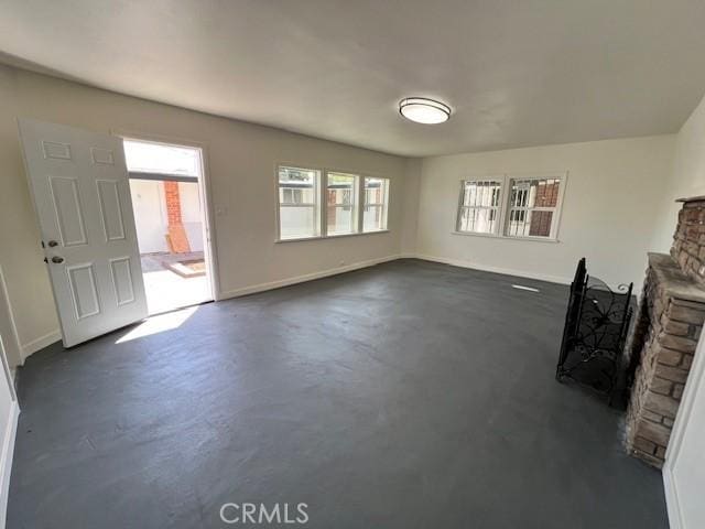 unfurnished living room with a stone fireplace