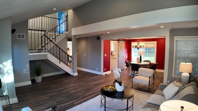 living room featuring a barn door and dark wood-type flooring