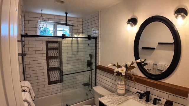 full bathroom featuring tasteful backsplash, vanity, shower / bath combination with glass door, and toilet