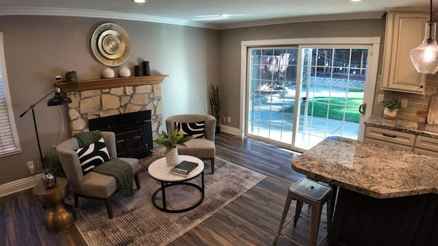 sitting room with ornamental molding, dark hardwood / wood-style floors, and a fireplace