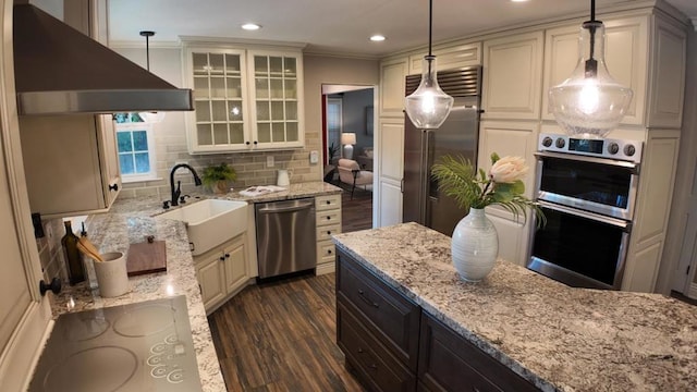 kitchen featuring extractor fan, decorative light fixtures, stainless steel appliances, and sink