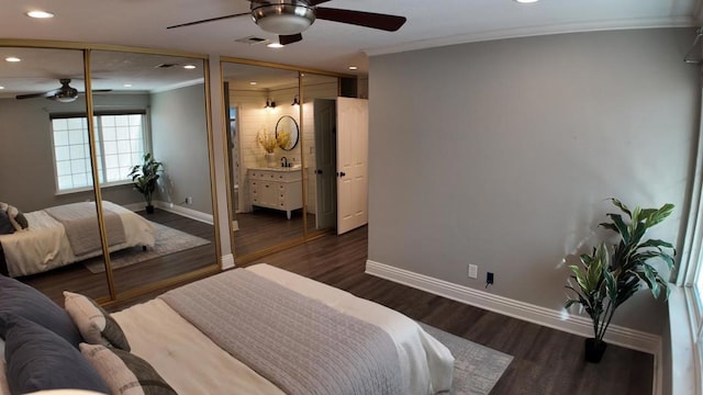 bedroom with crown molding, ensuite bath, ceiling fan, dark hardwood / wood-style floors, and a closet