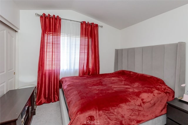 carpeted bedroom with lofted ceiling