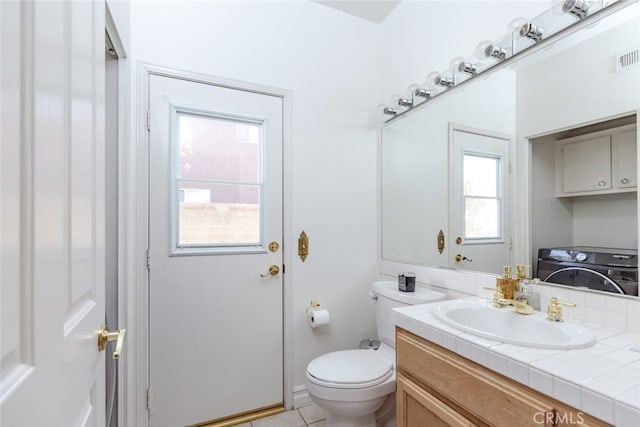 bathroom with tile patterned flooring, washer / dryer, vanity, and toilet