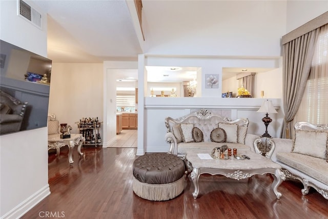 living area featuring hardwood / wood-style floors and a towering ceiling