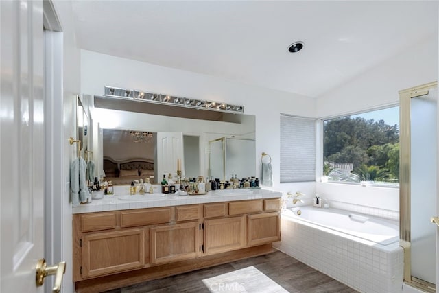 bathroom featuring hardwood / wood-style floors, vanity, separate shower and tub, and lofted ceiling