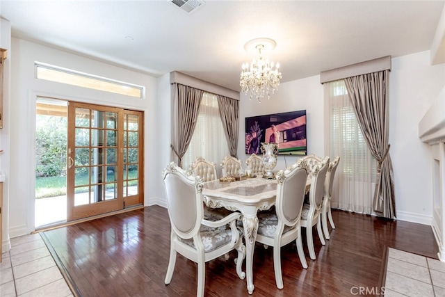 dining space featuring wood-type flooring and a notable chandelier