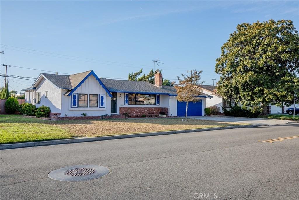 ranch-style home with a garage and a front lawn