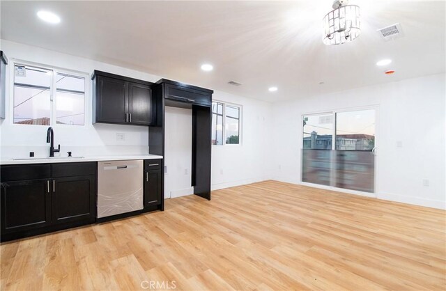 kitchen featuring dishwasher, light hardwood / wood-style flooring, hanging light fixtures, and sink